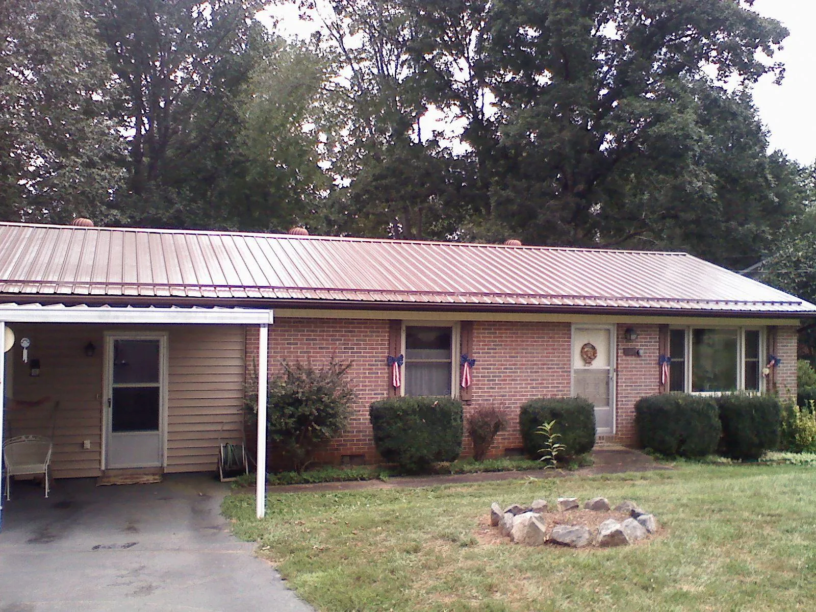 Bronze metal roof and carport on a brick ranch home — Roof Repair work by our crew in Hopedale